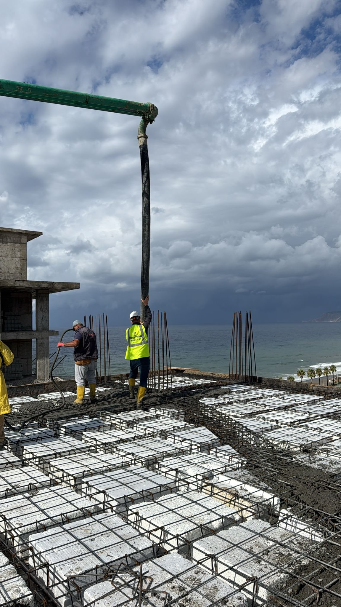 Baustellenfoto von Milan Towers: Betonarbeiten auf einer oberen Decke, dahinter das Meer, Oktober 2025
