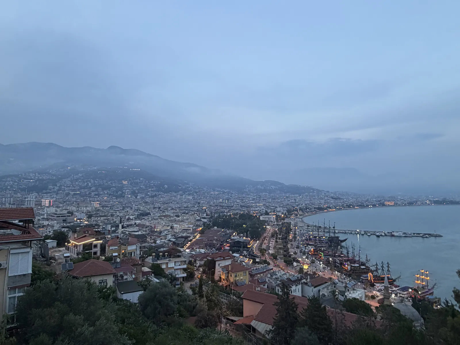 Alanya in der Abenddämmerung, Blick von oben über die Stadt auf Hafen, Bucht und Berge