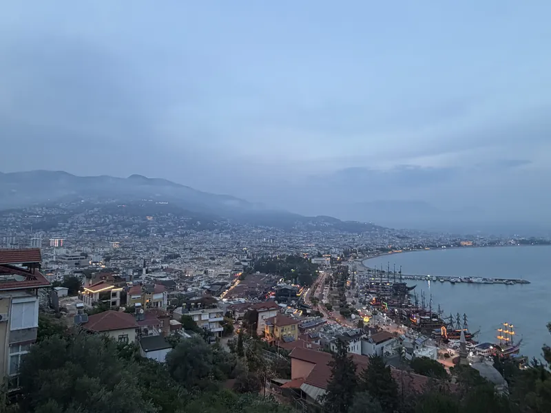 Alanya in der Abenddämmerung, Blick von oben über die Stadt auf Hafen, Bucht und Berge