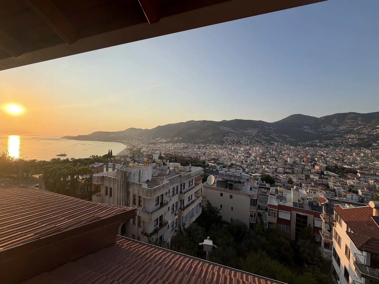 Abendsonne über Alanya im August, Blick vom Burgberg über die Dächer auf die Bucht und das Taurusgebirge